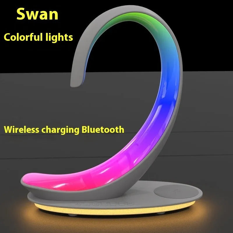White swan-shaped desktop device with wireless charging surface, Bluetooth speaker, and colourful atmosphere lighting