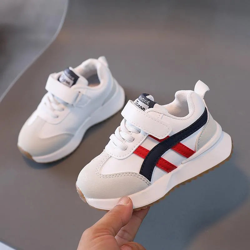 Children's solid-colour Velcro sneakers in synthetic leather with a rubber sole.