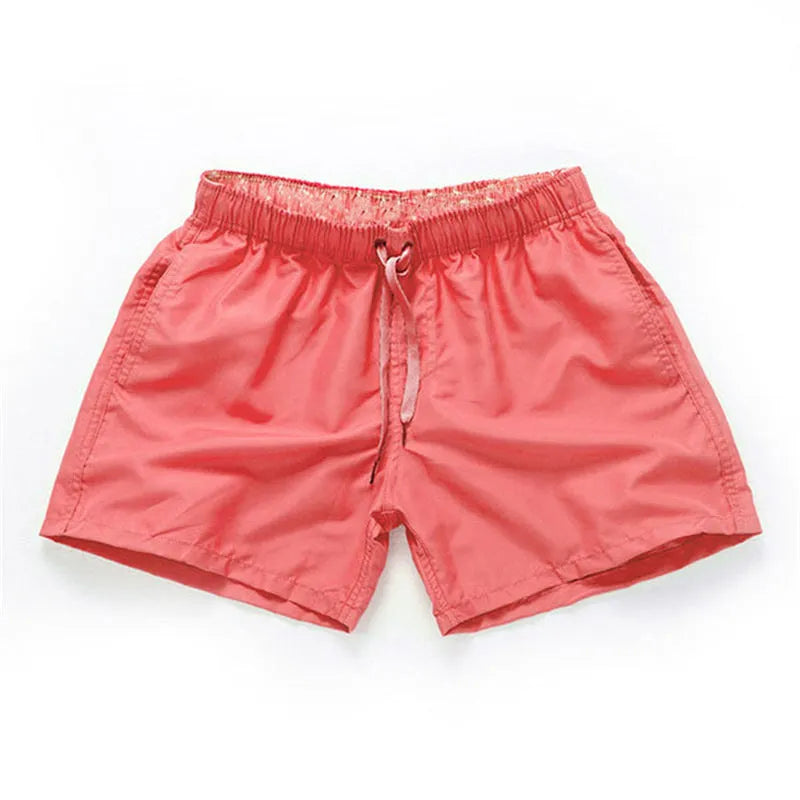 Men's polyester straight-leg surf shorts on a hanger, available in multiple solid colours.