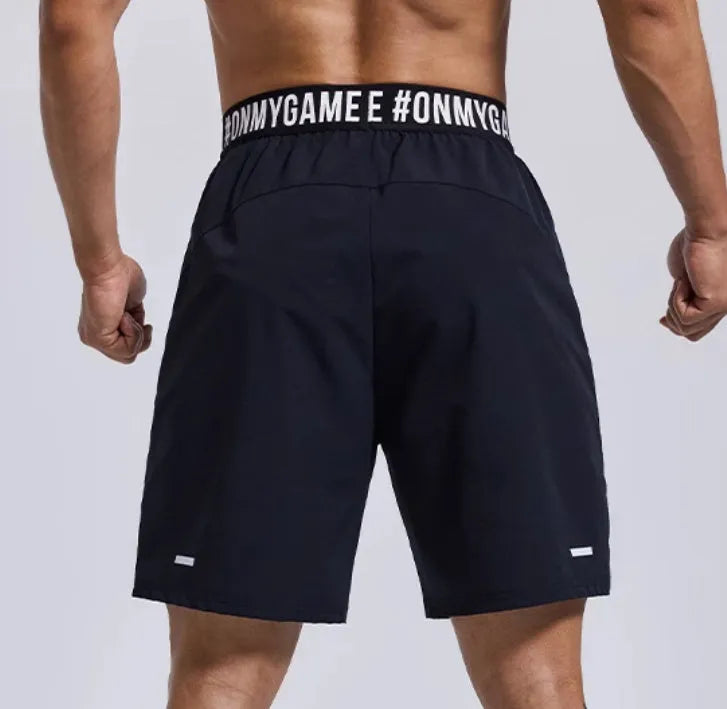 Men's loose black sports shorts with letter print and elastic waist.