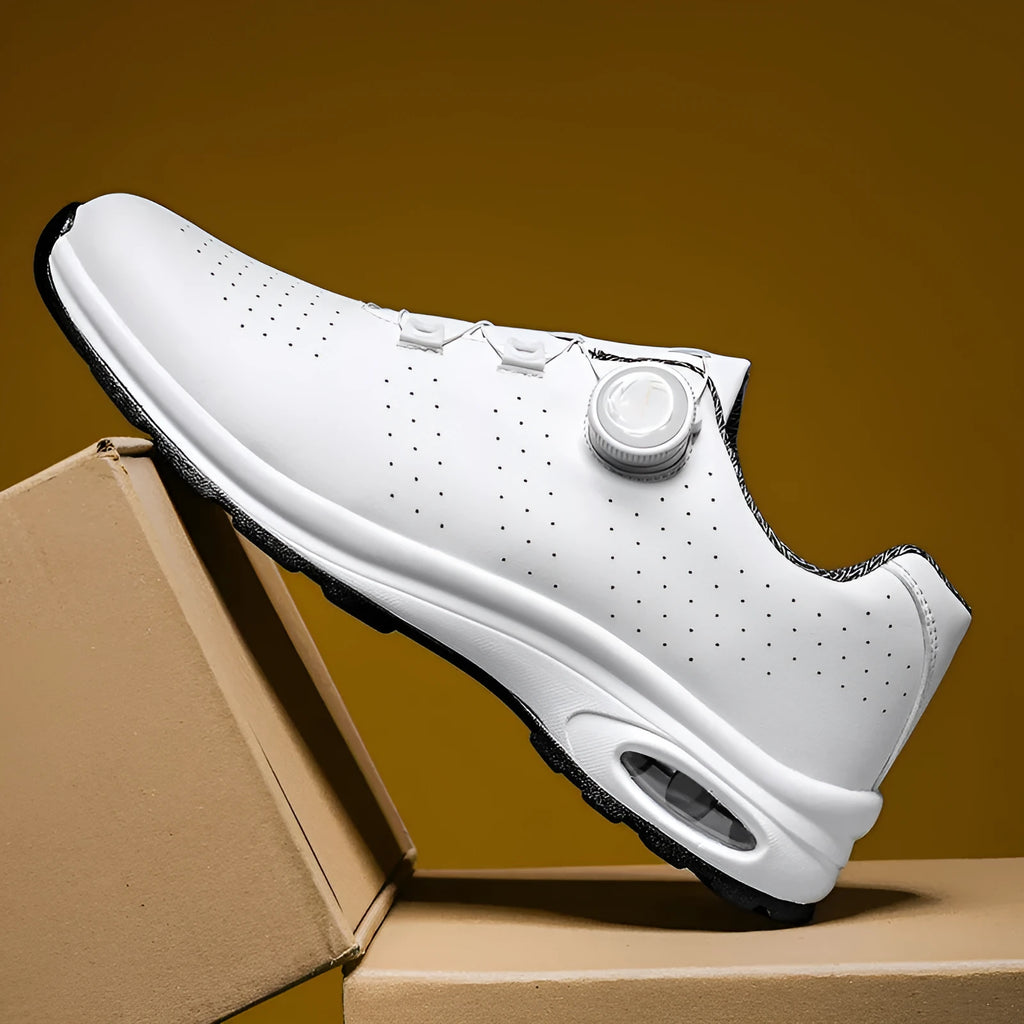 Black and white low top mesh tennis shoes with a round toe and flat composite sole on a plain background.