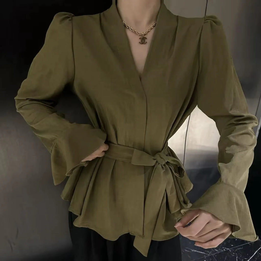 Women's black French-style shirt with an irregular collar and long bell sleeves, showing the tied front closure.