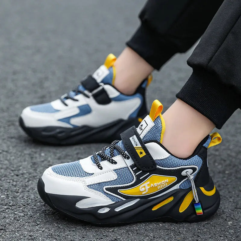 Boys' blue and black Velcro fastening sports running shoes on a white background.
