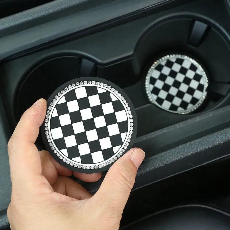 Plastic car water cup mat in black and white checkerboard with drill detailing on a non-slip surface for cup holder use