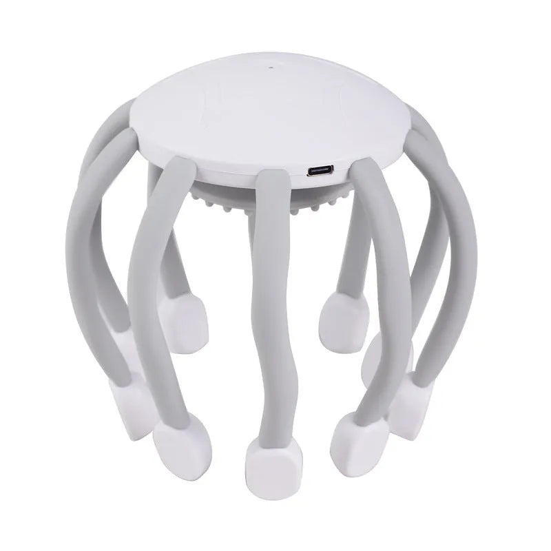 Black or white electric head massager with multiple plastic claws for scalp vibration and relaxation.