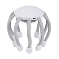 Black or white electric head massager with multiple plastic claws for scalp vibration and relaxation.