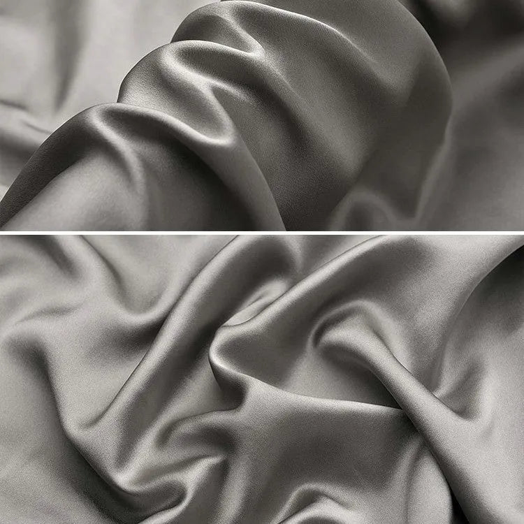 Dark gray 19 M silk envelope pillowcase with envelope closure on a bed.