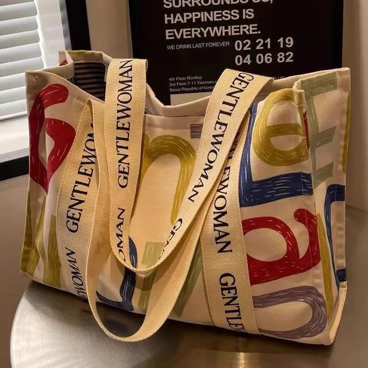 Large canvas shoulder tote bag with printed design, shown in available colour and pattern options.