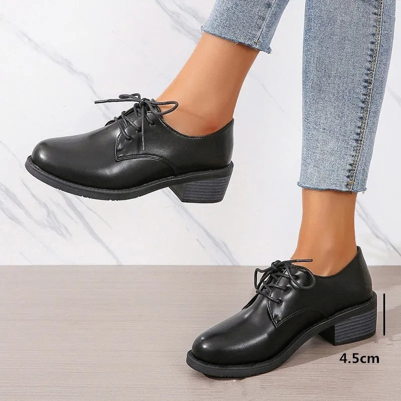 Black women's work shoes with a thick chunky heel and pointed toe.