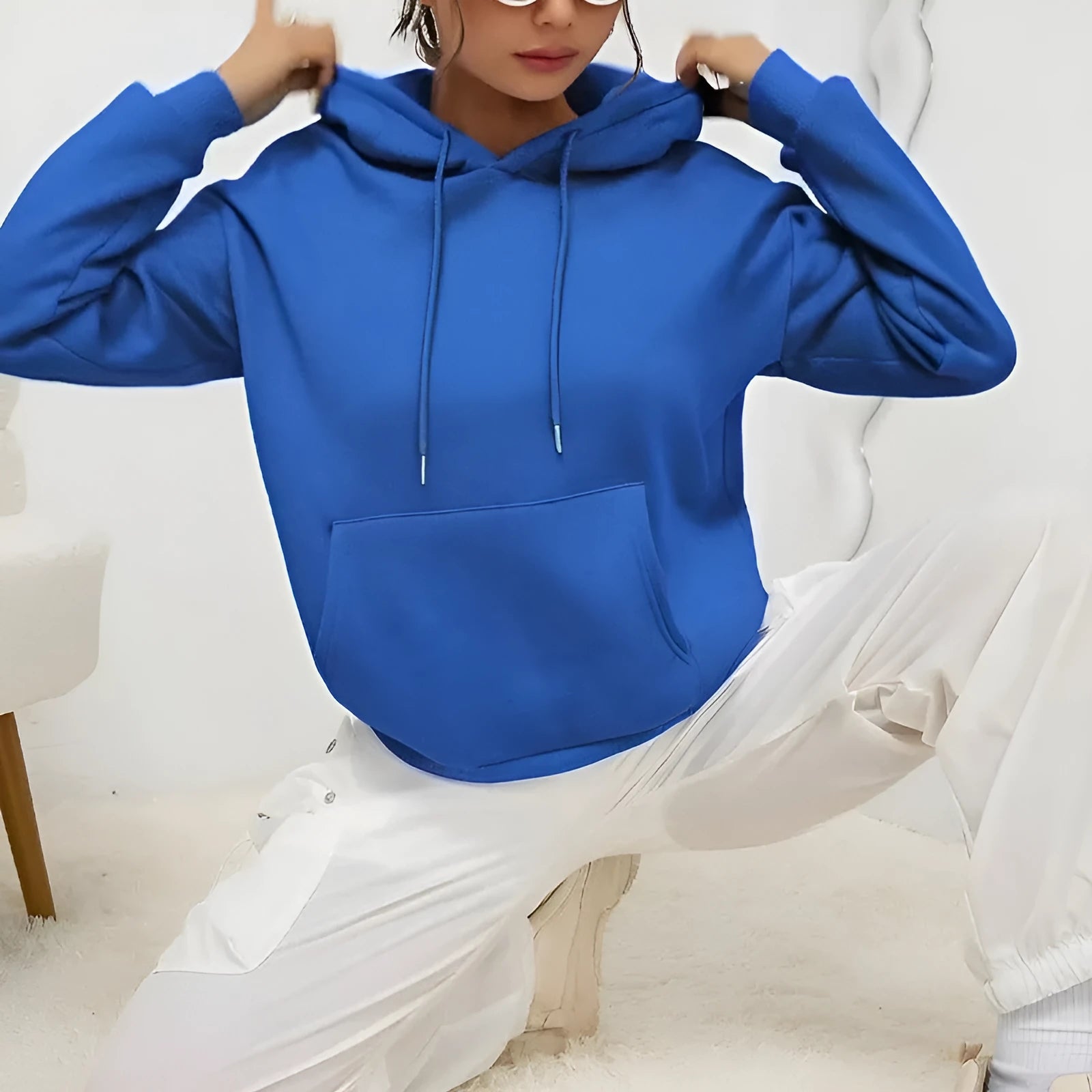 Women's loose black drawstring pocket sweatshirt with long sleeves and a front kangaroo pouch.
