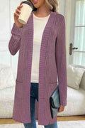 Black oversized knitted cardigan jacket with long sleeves and loose pockets.