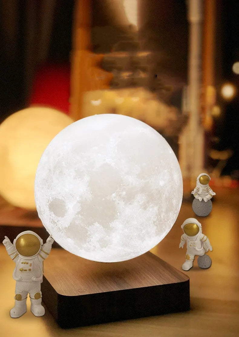 Maglev floating moon planet night light with LED illumination and astronaut figures on a dark surface.