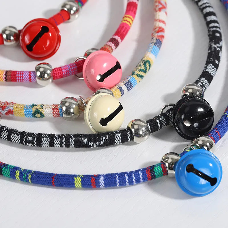 Colourful adjustable pet collar with ethnic patterns and a small metal bell attached, shown in multiple colour options.