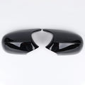 A pair of black and carbon pattern ABS plastic rearview mirror housing shells for a BMW 3 Series E90.