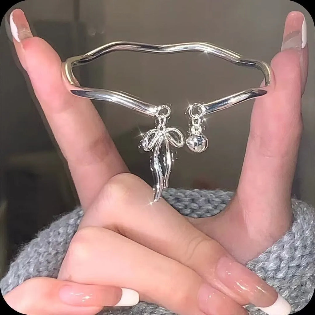 Adjustable silver bracelet with bow design and opening clasp on zinc alloy base