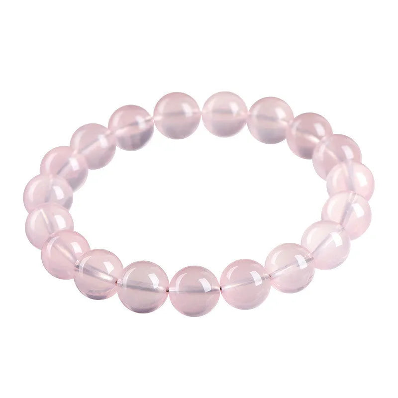 Women's natural starlight crystal round bead bracelet in pink on a white background.