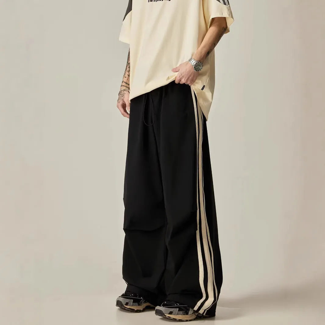 Black wide leg climbing trousers for men showing high waist and straight leg design on hanger.