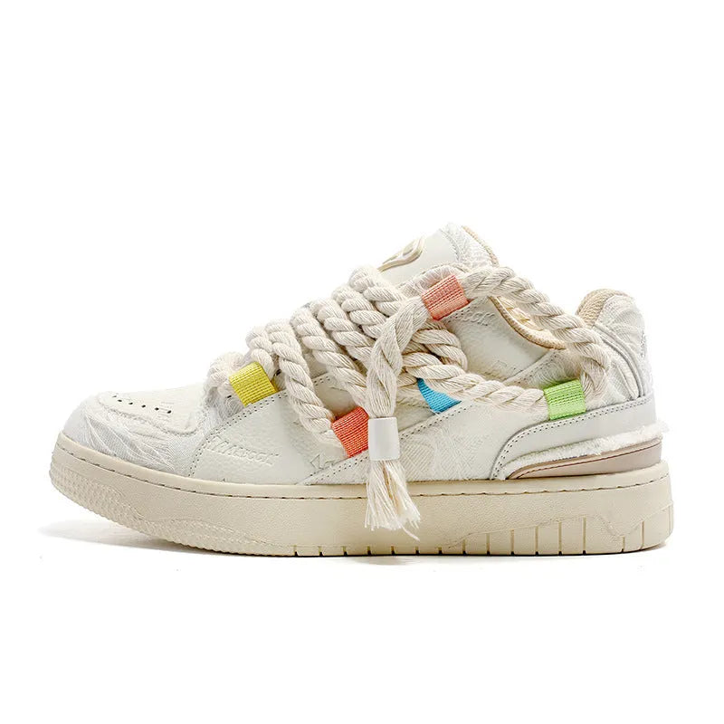 Cream coloured retro lace-up low-top skate shoes on a white background.