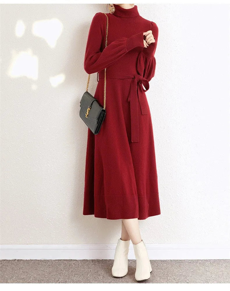 A woman wearing a rose red turtleneck long-sleeve knit dress with an elastic waist and loose hem.