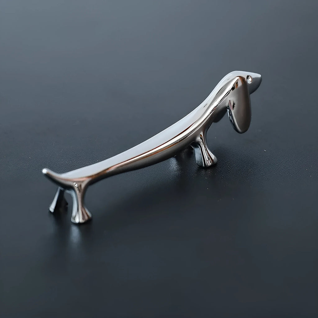 Silver zinc alloy sausage dog chopstick rest knife holder on desk with pen and chopsticks