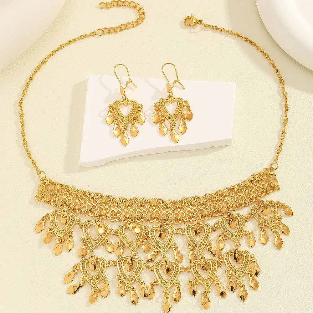 Gold alloy heart-shaped hollow necklace and matching earrings set on display with multiple hanging leaf ornaments