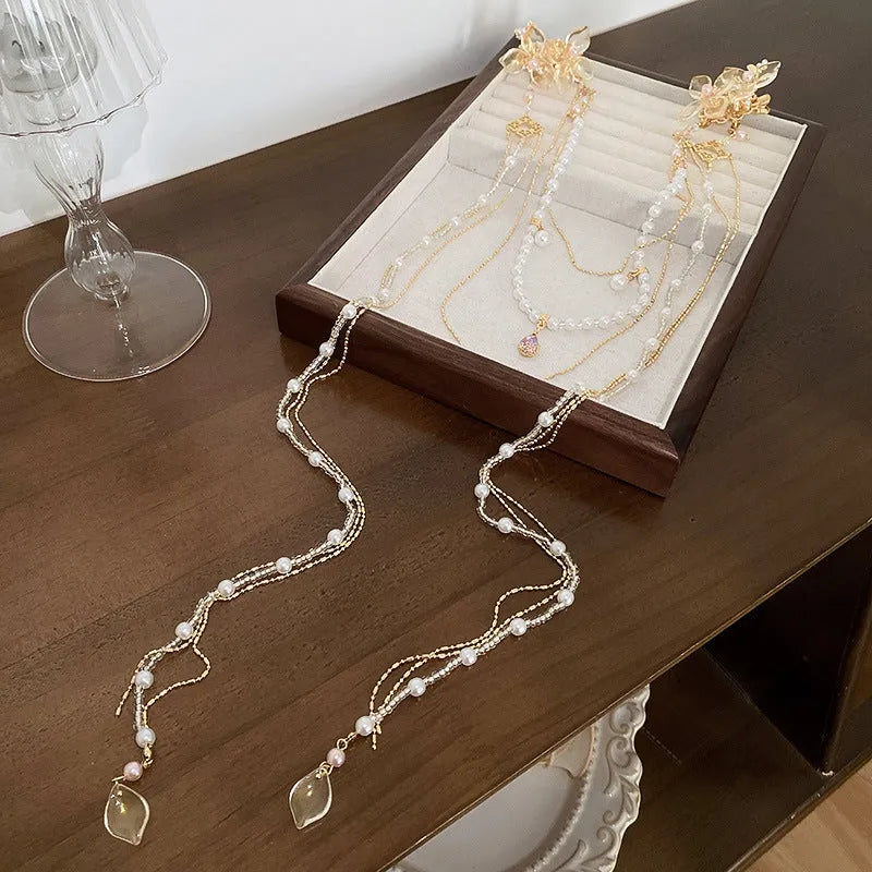 Gold women's hairpin with white pearl and clear diamond floral decoration and a long dangling tassel