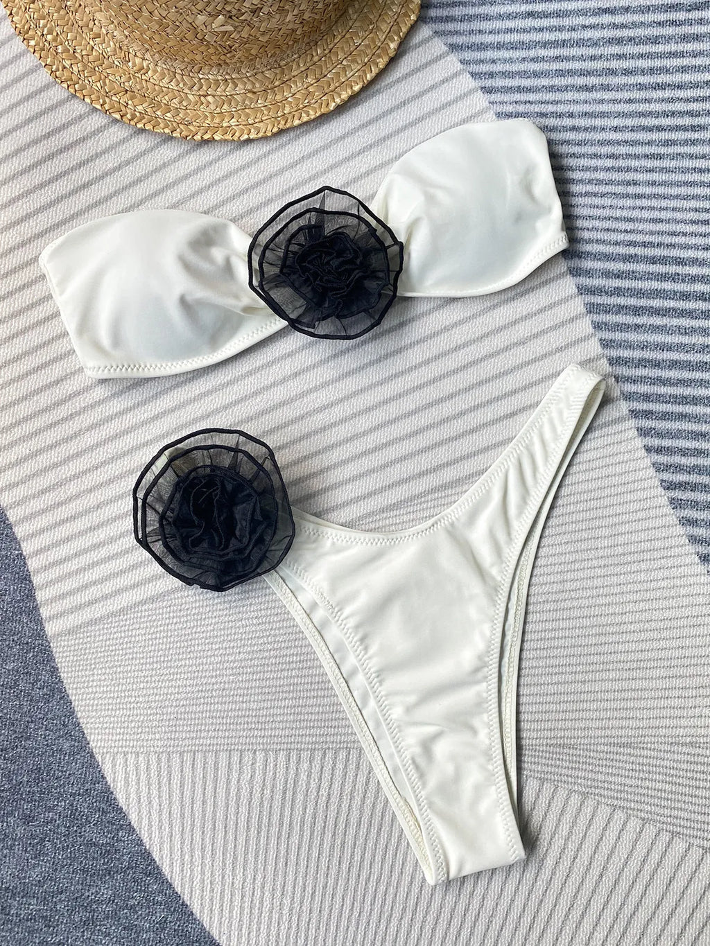 A striped bikini swimsuit with a cross-back tube top featuring a 3D flower and split leg briefs.