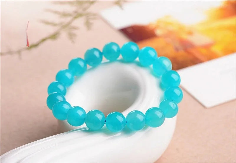 Polished Amazonite scattered beads in ice colour with size options for jewellery making next to crystal bracelet