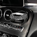 White rhinestone cup holder bracket clipped onto a car air vent