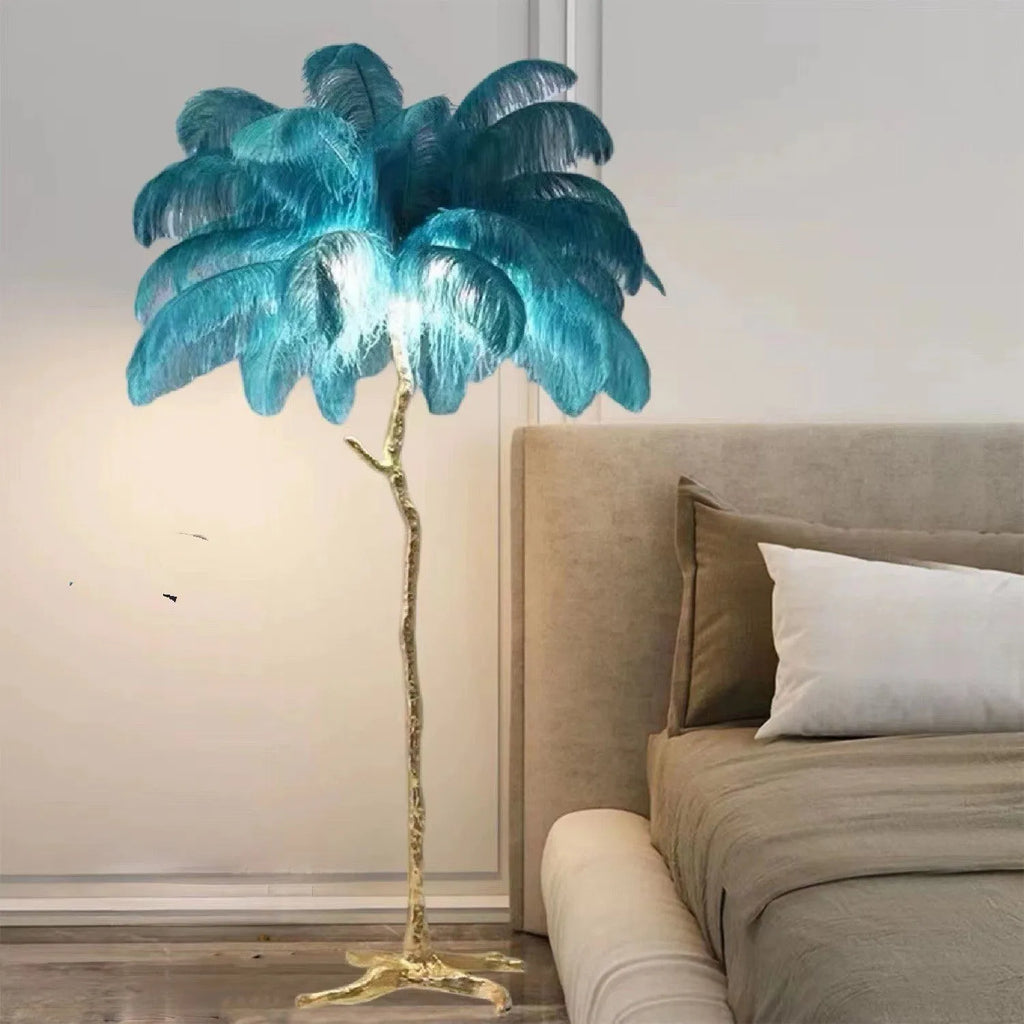 Tall decorative floor lamp with a cluster of white resin feathers next to a sofa.