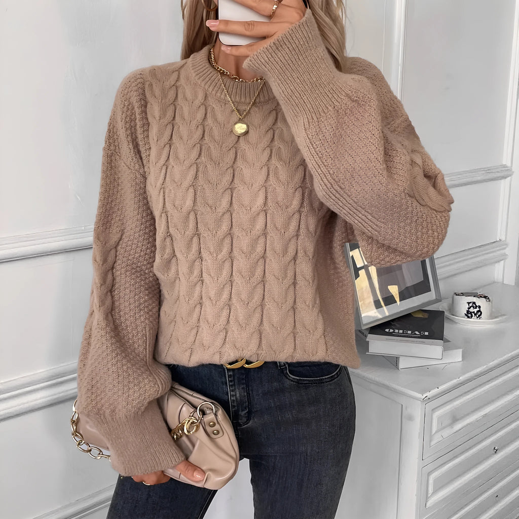 A woman's loose-fit round neck sweater in a solid colour, shown in a casual street fashion style.