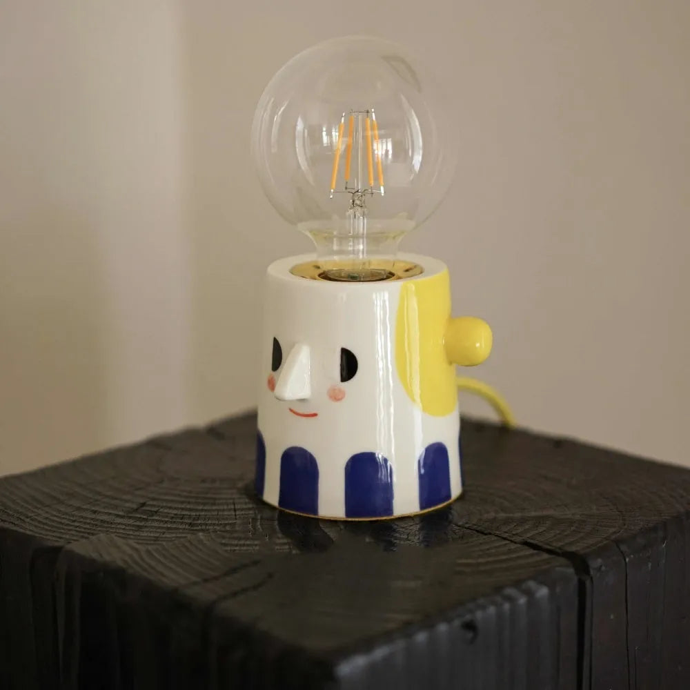 Handmade ceramic bedside lamp with spherical ball headlight shade on wooden nightstand