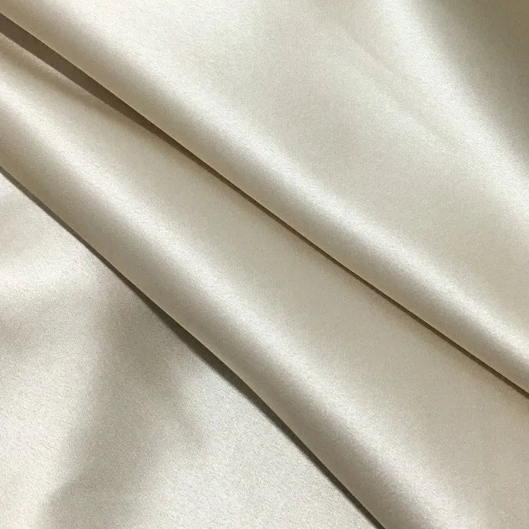 Dark gray 19 M silk envelope pillowcase with envelope closure on a bed.