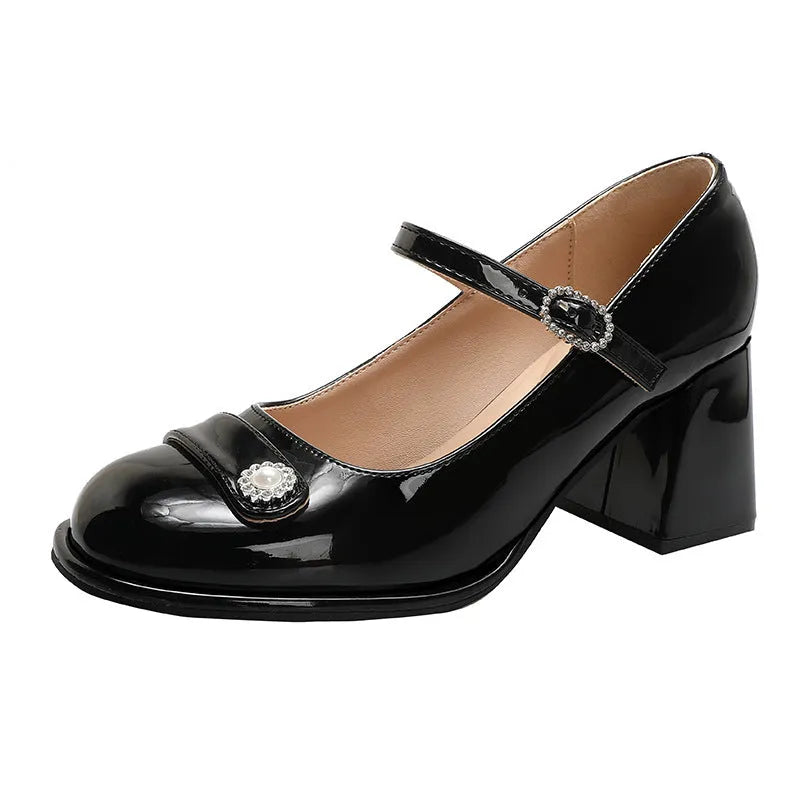 Women's black patent leather chunky heel shoes with round toe and buckle.
