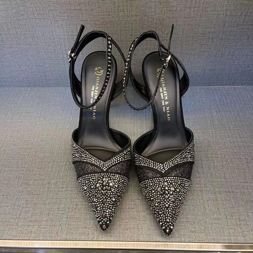 Women's black hollow high heel with stiletto heel, pointed toe, and red sole on a plain background.