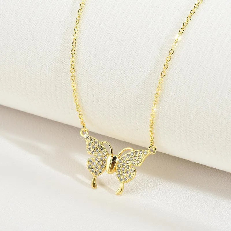 Gold titanium steel clavicle necklace with magnetic snap and butterfly pendant on twisted chain.