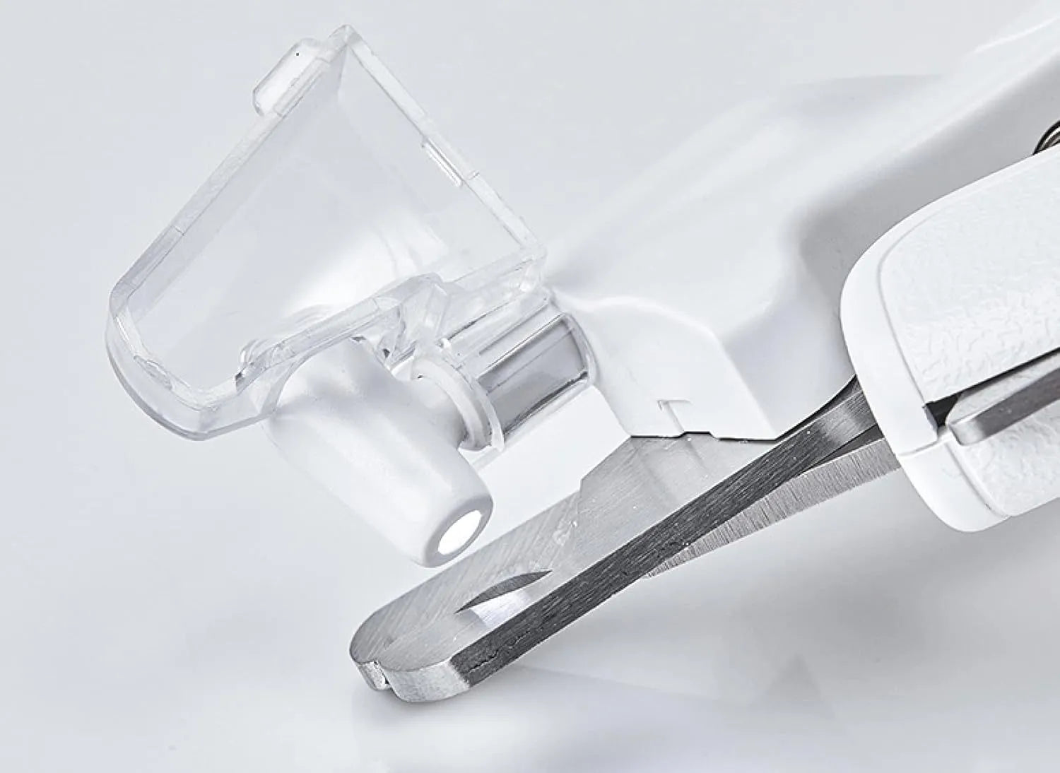 White pet nail clippers with LED light, transparent guard, and a separate nail file on a plain background.
