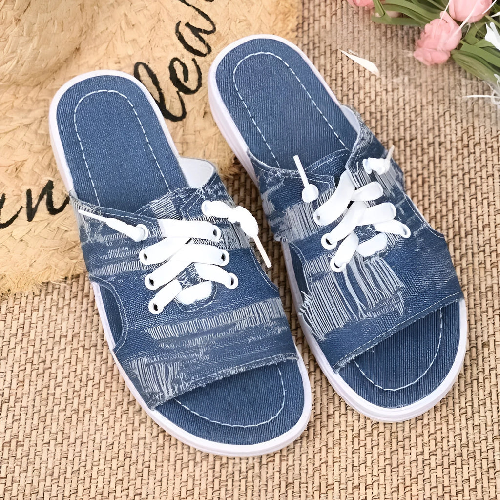 Blue women's Roman style canvas slippers with a flat rubber sole on a white background.