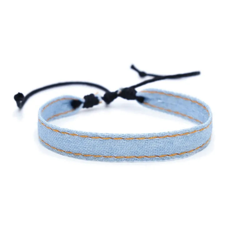 Mixed material denim-style fabric bracelet wristband for carrying travel souvenirs.