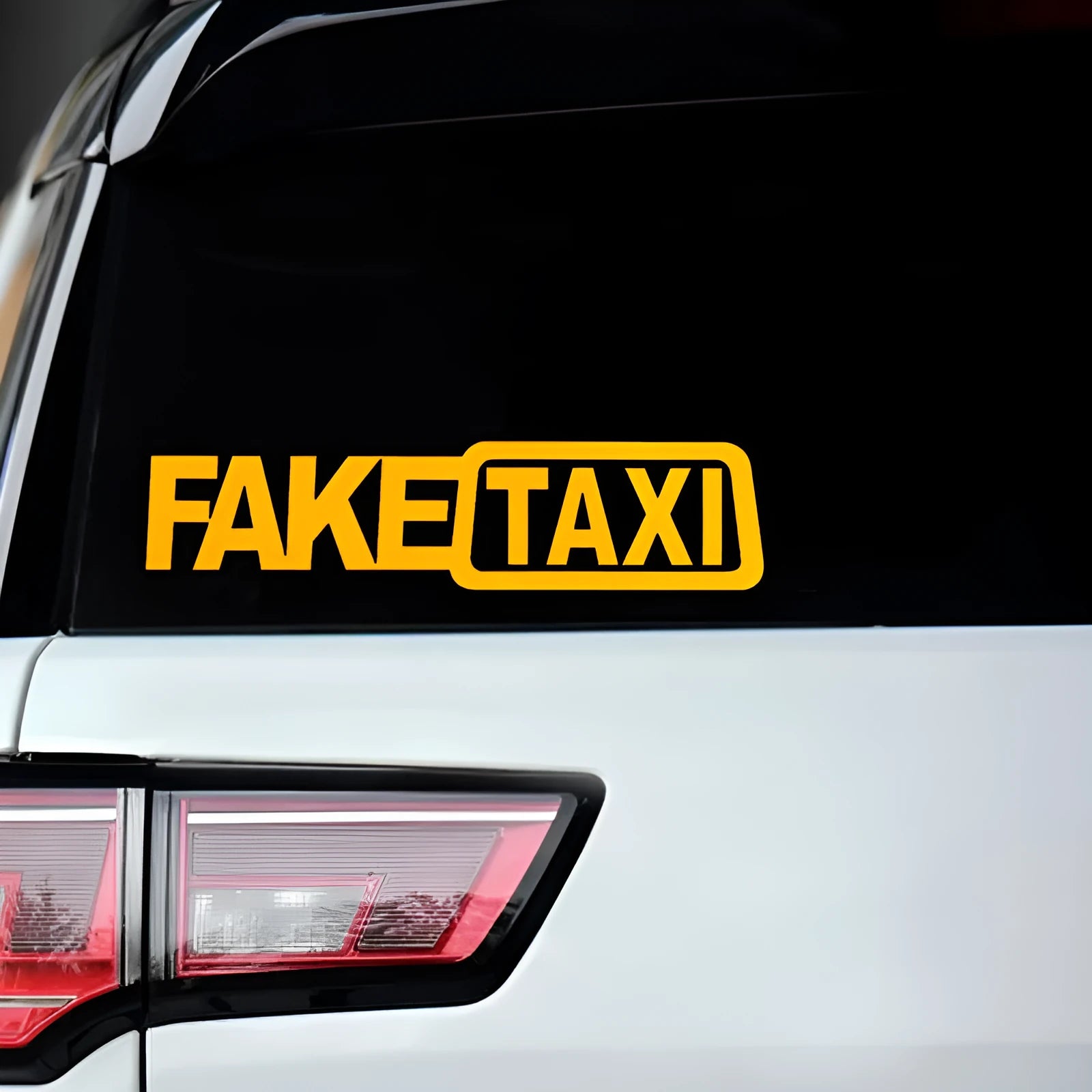 Waterproof FAKE TAXI car warning sticker in yellow, 20 cm by 8 cm, on a car window.