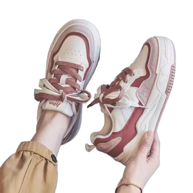 Pink and white low-top sneakers with rubber soles and imitation leather lining