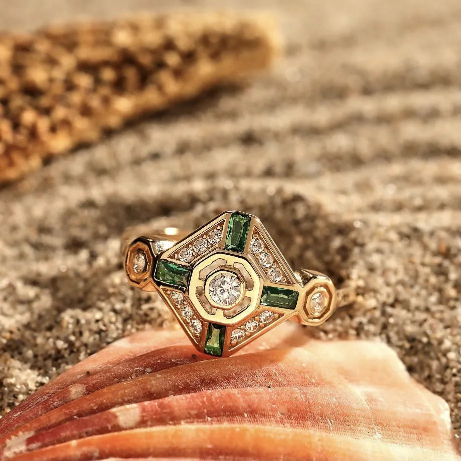 Square geometric women's ring with green diamond colour on a hand.