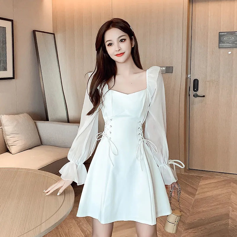 White women's chiffon dress with patchwork detail, long sleeves, and a long slimming skirt.