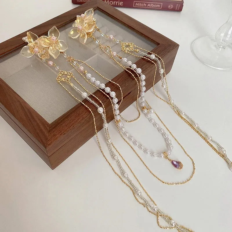 Gold women's hairpin with white pearl and clear diamond floral decoration and a long dangling tassel