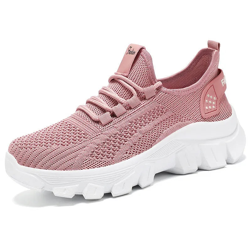 Women's white Flyknit sneakers with thick PVC sole and lace-up fastening on a neutral background.