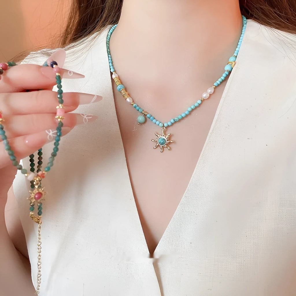 Freshwater pearl necklace with sun motif stone pendant on an adjustable clavicle chain.