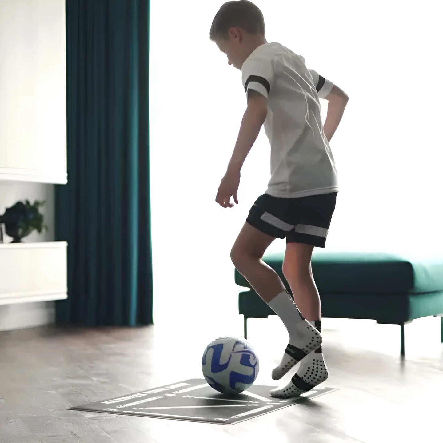 Black rectangular football training mat on grass, measuring 60 by 90 centimetres.