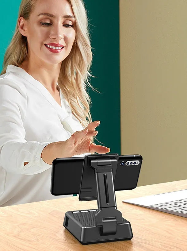 Black mobile phone broadcaster stand with Bluetooth speaker and microphone on a desk