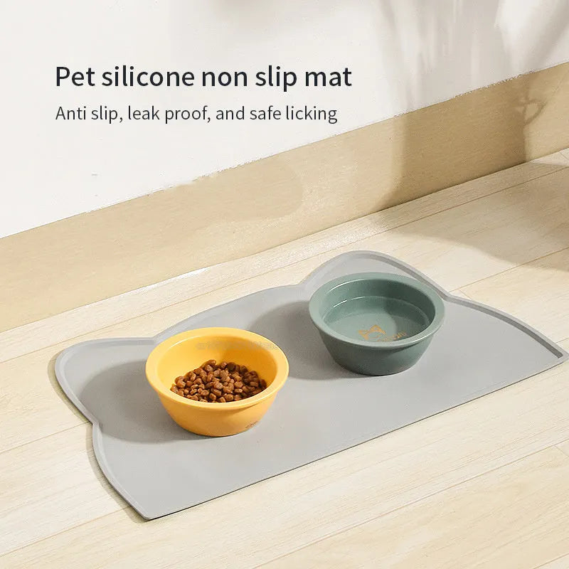 Waterproof silicone pet feeding mat in grey, cat head shape, 44x24cm, with a pet bowl on top