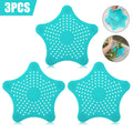 Three silicone starfish sink drain strainers in white, blue, and green with suction cups on bottom